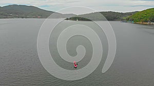 A young man and his son paddle in the inflatable kayak in a sea or in a lake