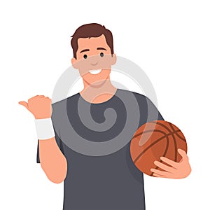 Young man holding basketball ball over white background smiling with happy face looking and pointing to the side with thumb up