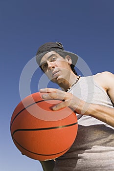 Young Man Holding Basketball low angle view. photo