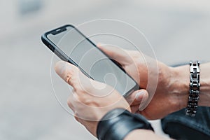 Young man holding black mobile phone .