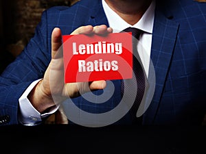 Young man holding a blank card in hands. Conceptual photo about Lending Ratios with written text