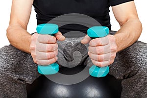 Young man holding blue dumbbells