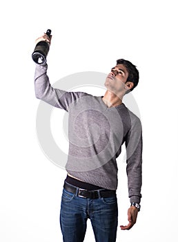 Young man holding bottle of champagne or white