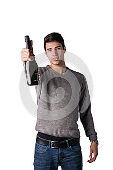 Young man holding bottle of champagne or white