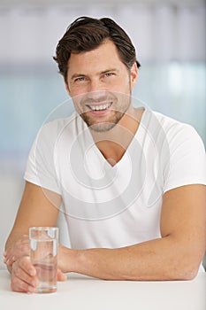 Young man holding bottle water smiling