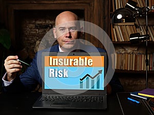 Young man holding a card in hands. Conceptual photo about Insurable Risk with written text