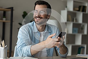 Young man holding cell look away excited with new opportunity