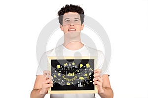 Young man holding a chalkboard with business sketch.