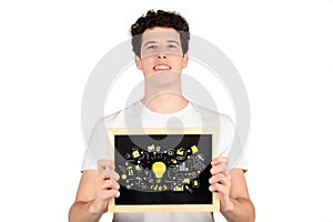 Young man holding a chalkboard with business sketch.