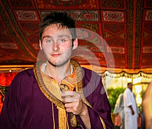 Young man holding a cobra snake.