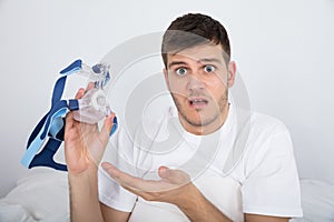 Young Man Holding CPAP Machine