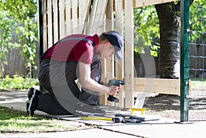 Young man holding drill-drive. Carpenter works