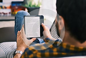 Young Man Holding Ereader And Reading Ebook