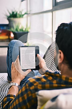 Young Man Holding Ereader And Reading Ebook