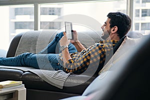 Young Man Holding Ereader And Reading Ebook