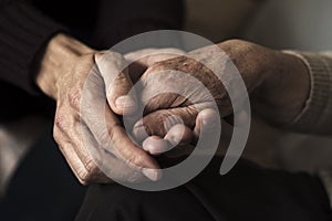 Young man holding the hand of an old woman