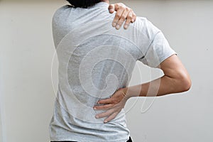 Young man holding his back in pain. Medical concept