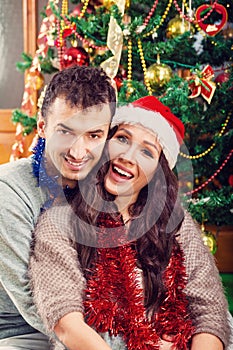 Young man holding his girlfriend in his arms on Christmas