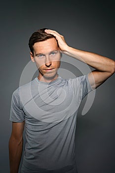 Young man holding his head. Gesture of annoyance or headache. photo