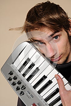 Young man holding his midi keyboard