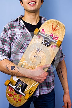 Young man holding his skateboard