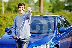 Young man holding key of his new car