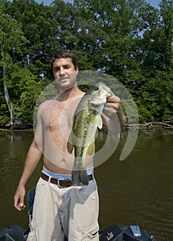 Young man holding large mouth bass