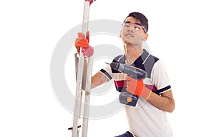 Young man holding ledder and electric screwdriver