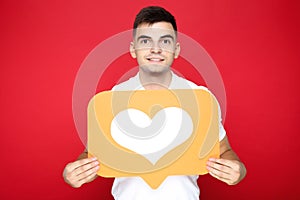 Young man holding paper heart