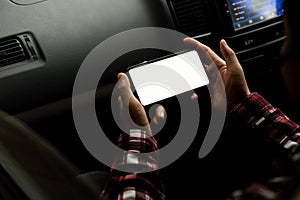 Young man holding a phone with white screen in a GPS routing concept car