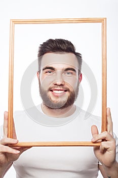 Young man holding picture frame