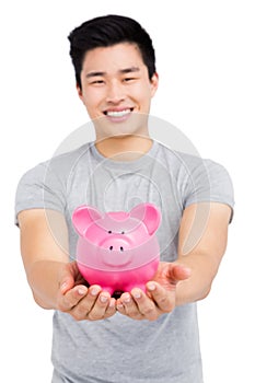 Young man holding a piggy bank