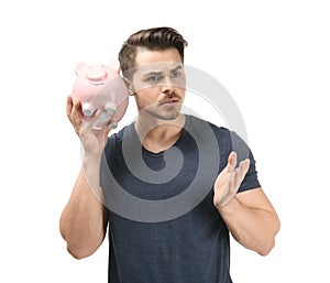 Young man holding piggy bank on white background. Money savings concept