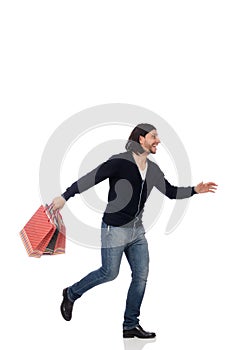 The young man holding plastic bags isolated on white