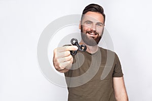 Young man holding and playing with fidget spinner.