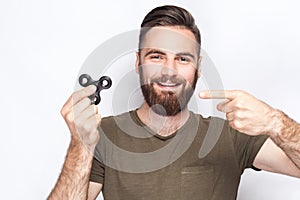 Young man holding and playing with fidget spinner.