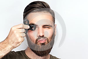 Young man holding and playing with fidget spinner.