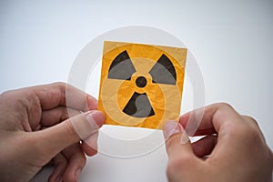 A young man holding a radiation warning sign in his hands