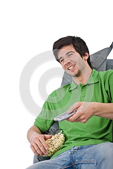 Young man holding remote control watch television