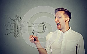 Young man holding screaming in megaphone