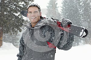 Young Man Holding Skis In Snow