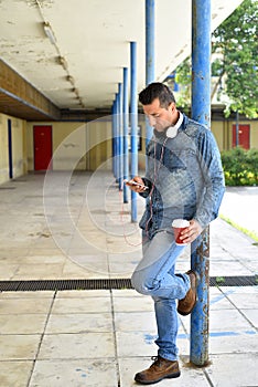 Young man holding smartphone and cup of coffe