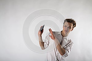 Young man holding smartphone in his hands. Antipathy, dislike and refuse concept