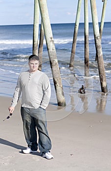 Young Man Holding Sunglasses at the Beach