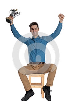 Young man holding trophy and celebrating victory