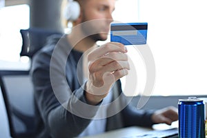 Young man holding and using credit card for game money top up, close up credit card
