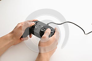 Young man holding video game controller on white background