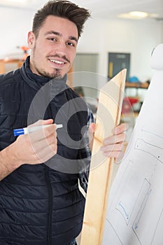 young man holding wood by flipchart