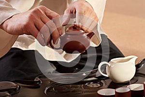 A young man holds a Chinese tea ceremony