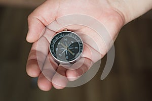 Young man holds a compass in his hand